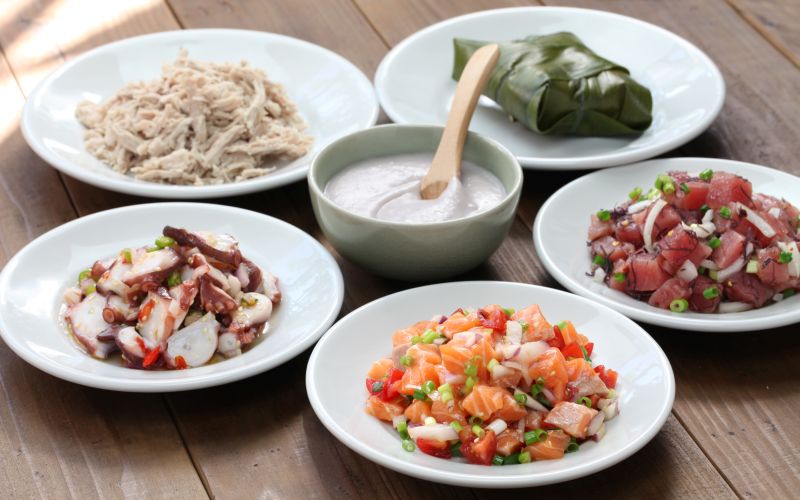 Traditional Hawaiian food, including pole, kalua pork, lomi lomi salmon