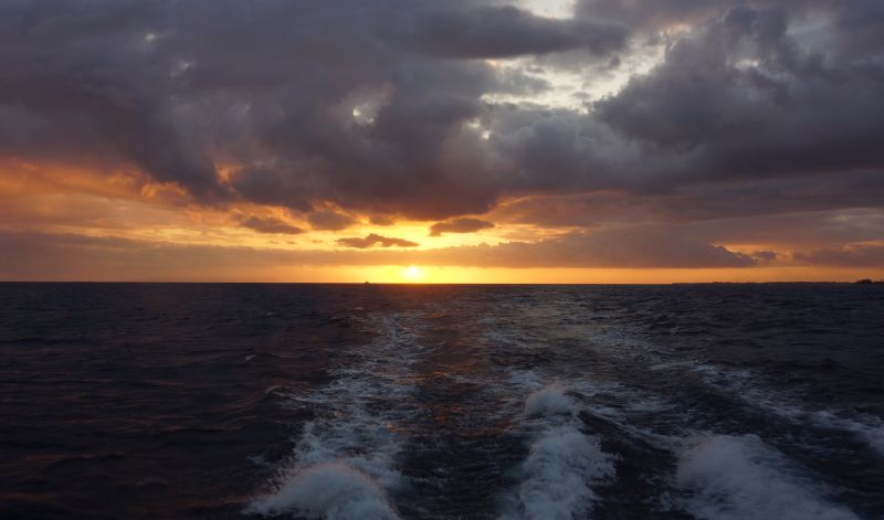 View of sunset from Holo Holo Charters catamaran near Na Pali Coast, Kauai