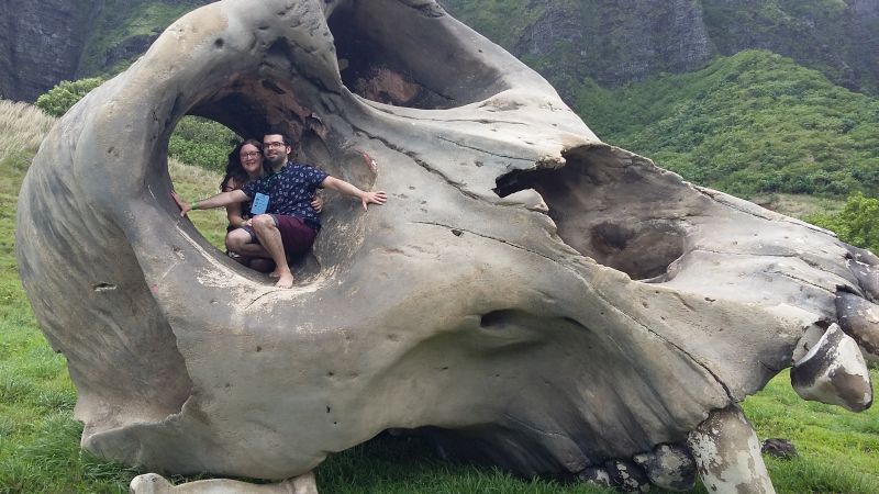 Posing inside the eye of a large dinosaur skull