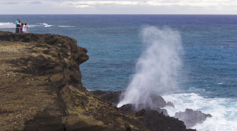 People watching the Halona Blowhole erupting at the southeast corner of Oahu