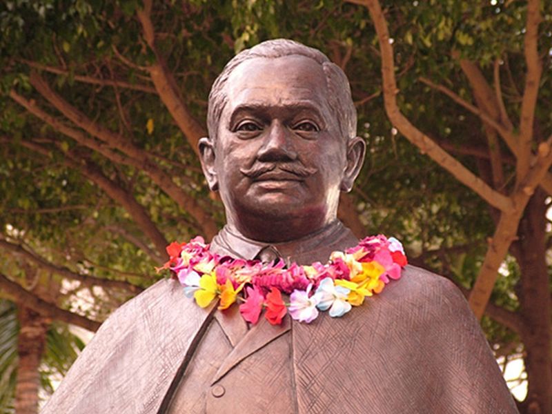 Prince Kuhio statue in Waikiki with leis around his neck, dressed in business suit similar to what he wore as a delegate to congress.