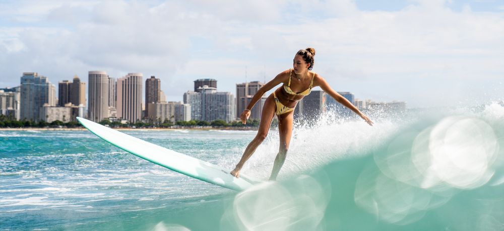 A girl on surfboard with Waikiki beach in background