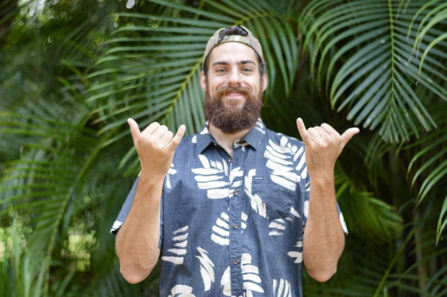 A man in Hawaii makes the shaka with both hands.