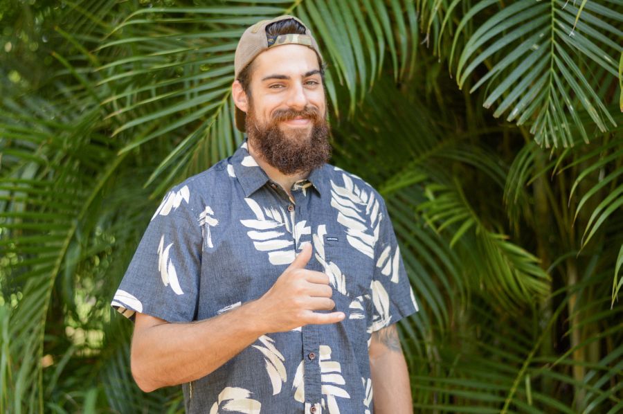 A smiling man in Hawaii makes the shaka.