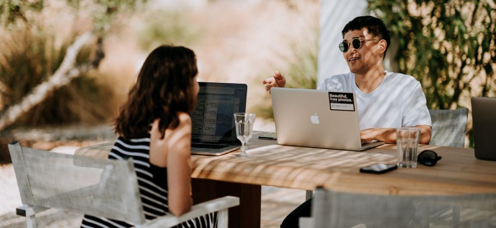 How to freelance in Hawaii - a man and a woman discussing business outdoors