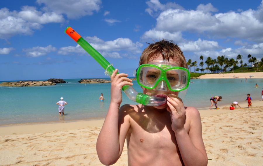 A boy on a beach in Hawaii in snorkeling gear