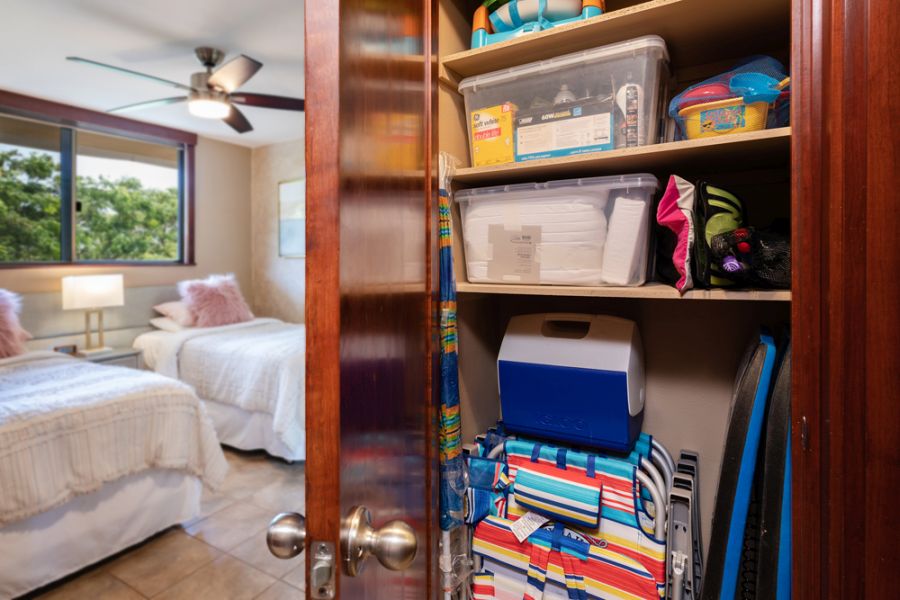 Vacation rental bedroom closet, stocked with items, such as beach chars, boogie boards, sand toys.