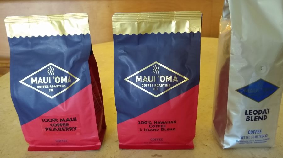 Three bags of coffee beans roasted by Maui Oma Coffee Roasters.