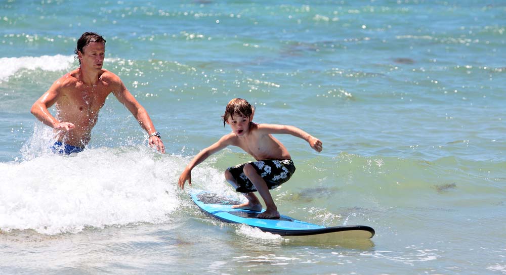 Beginner learning to surf at Breakwall near Lahaina Harbor, Maui