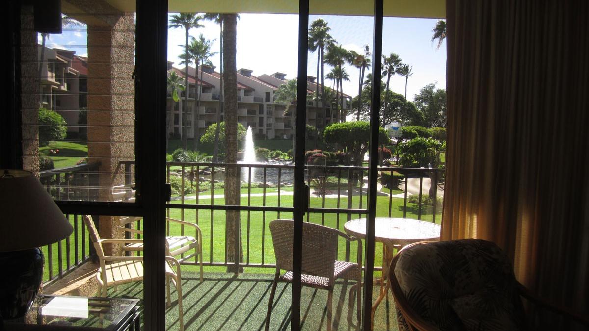 In side living room area looking out to beautiful gardens of ponds, fountains and immaculate landscaping