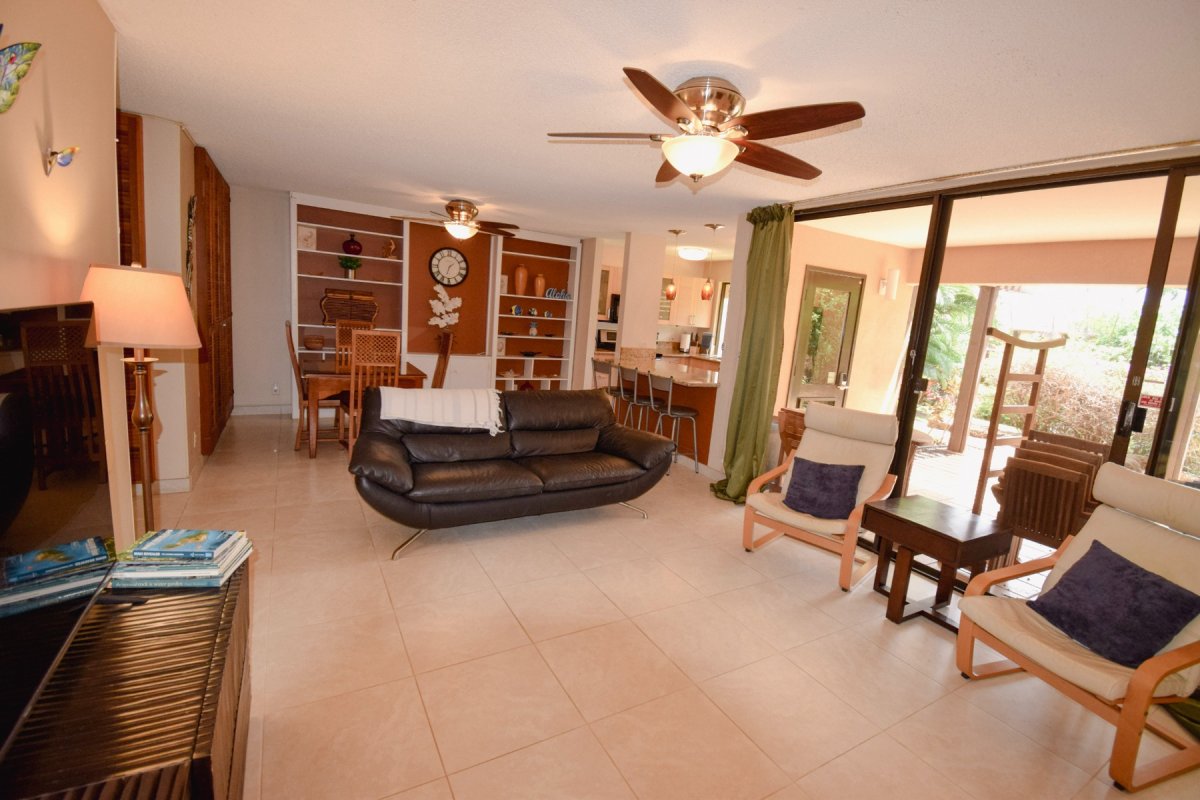 Open concept kitchen-dining-living room with large doors out to the lanai and spacious grounds.